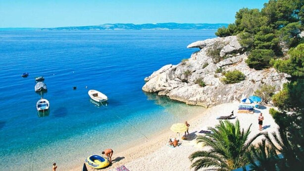 A beach with clear blue water, boats, and people. - Modern apartment in Dramalj near the sea (Dramalj)