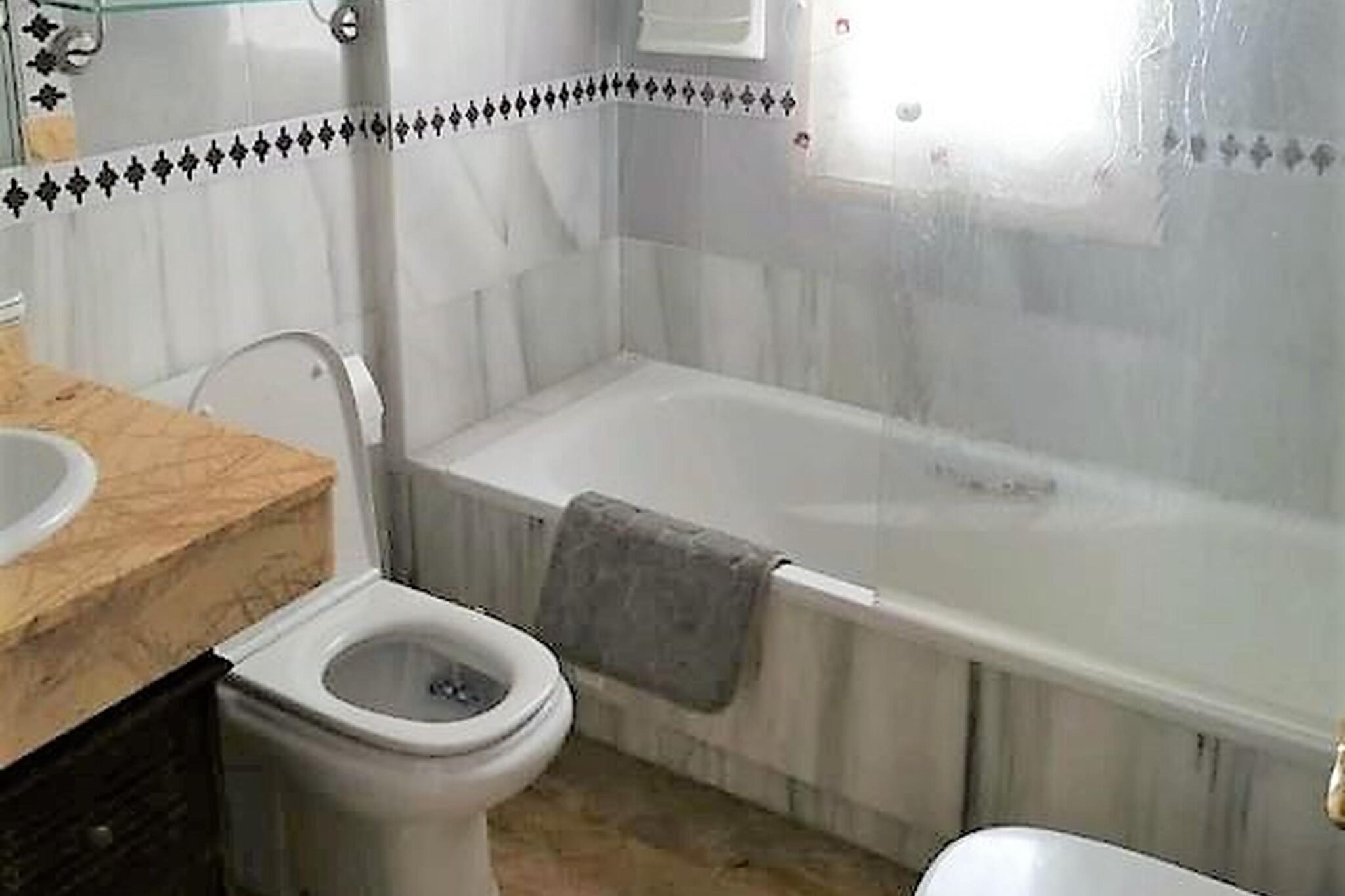 A bathroom with a toilet, sink, and bathtub.