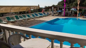 Un espace piscine équipé de chaises longues et de parasols.