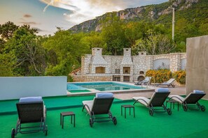 A stone building with a pool and lounge chairs on a green deck. - Charming holiday home in Bribir with private pool (Bribir)