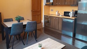 A compact kitchen with wooden cabinets, a microwave, a toaster, and a dishwasher. - T2 Apartment in Castle, 4 people, pool, pets allowed (Jausiers)