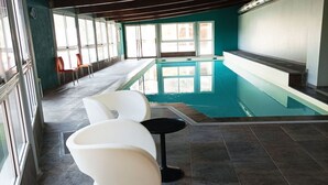 A modern indoor pool area with a tiled floor, a pool table, and a seating area with white chairs. - T2 Apartment in Castle, 4 people, pool, pets allowed (Jausiers)