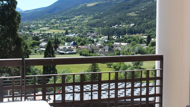 En balkon med udsigt over en landsby og bjerge.