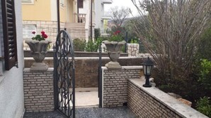 A gated entrance with a wrought iron gate, a stone pathway, and a brick wall. - Inviting apartment in Jadranovo with balcony/terrace (Jadranovo)