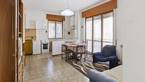 A compact living space with a dining area, kitchenette, and a seating area with a sofa and armchair. - Inviting apartment in Jadranovo with balcony/terrace (Jadranovo)