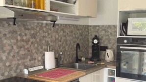 Eine moderne Küche mit Geschirrspüler, Kaffeemaschine und Mikrowelle.