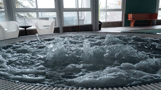 Een jacuzzi met een geribbelde bodem en een rasterpatroon rond de rand.