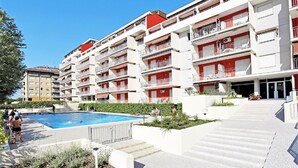 Un hôtel à plusieurs étages doté d’une piscine, de balcons et d’un jardin aménagé.