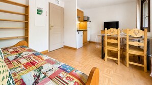 A compact room with a bed, a small kitchenette, a dining area with a table and chairs, and a television. - Pleasant ski-in/ski-out apartment with pool (Flumet)