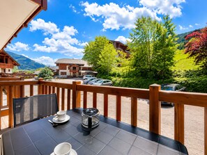 A balcony with a table, chairs, and a view of a mountain landscape. - Pleasant ski-in/ski-out apartment with pool (Flumet)
