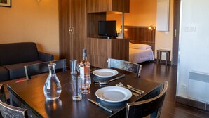 Hotelkamer met een eethoek, televisie, bed en badkamer.