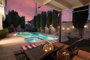 A backyard with a swimming pool, lounge chairs, and a covered patio area. - Dream Retreat-Remodeled 4BR w/ Pool & Spa and MORE (North Las Vegas)