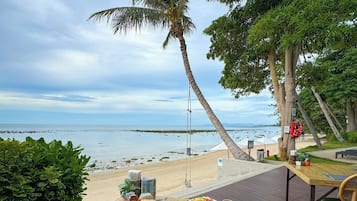 A table set for breakfast with a view of the beach and ocean.