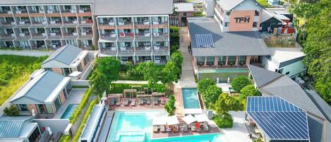 Un hotel con varias construcciones, piscina y paneles solares.
