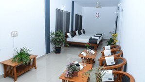 Una sala moderna con sofá, mesa de centro y sillas, un comedor con mesa y sillas, y un dormitorio con cama y cortinas.