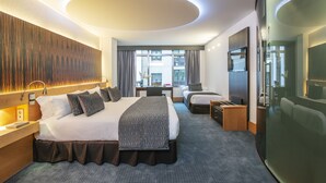 Une chambre d’hôtel moderne avec un grand lit, un bureau et une vue sur la ville.