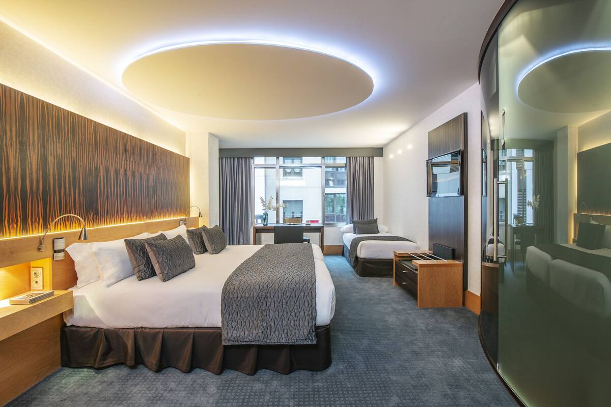 Une chambre d’hôtel moderne avec un grand lit, un bureau et une vue sur la ville.