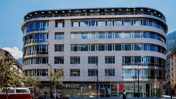 Un bâtiment moderne doté d’une façade incurvée, de grandes fenêtres et d’un toit plat.
