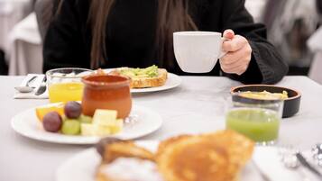 Et morgenbord med forskellig mad og en kop.