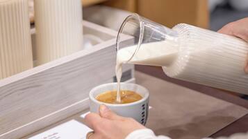 Qualcuno versa latte in una tazza di caffè.