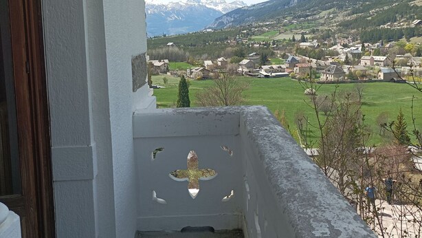 A balcony with a view of a village and mountains. - 2-BR Apartment in Castle in Jausiers for 6, balcony, pets allowed (Jausiers)
