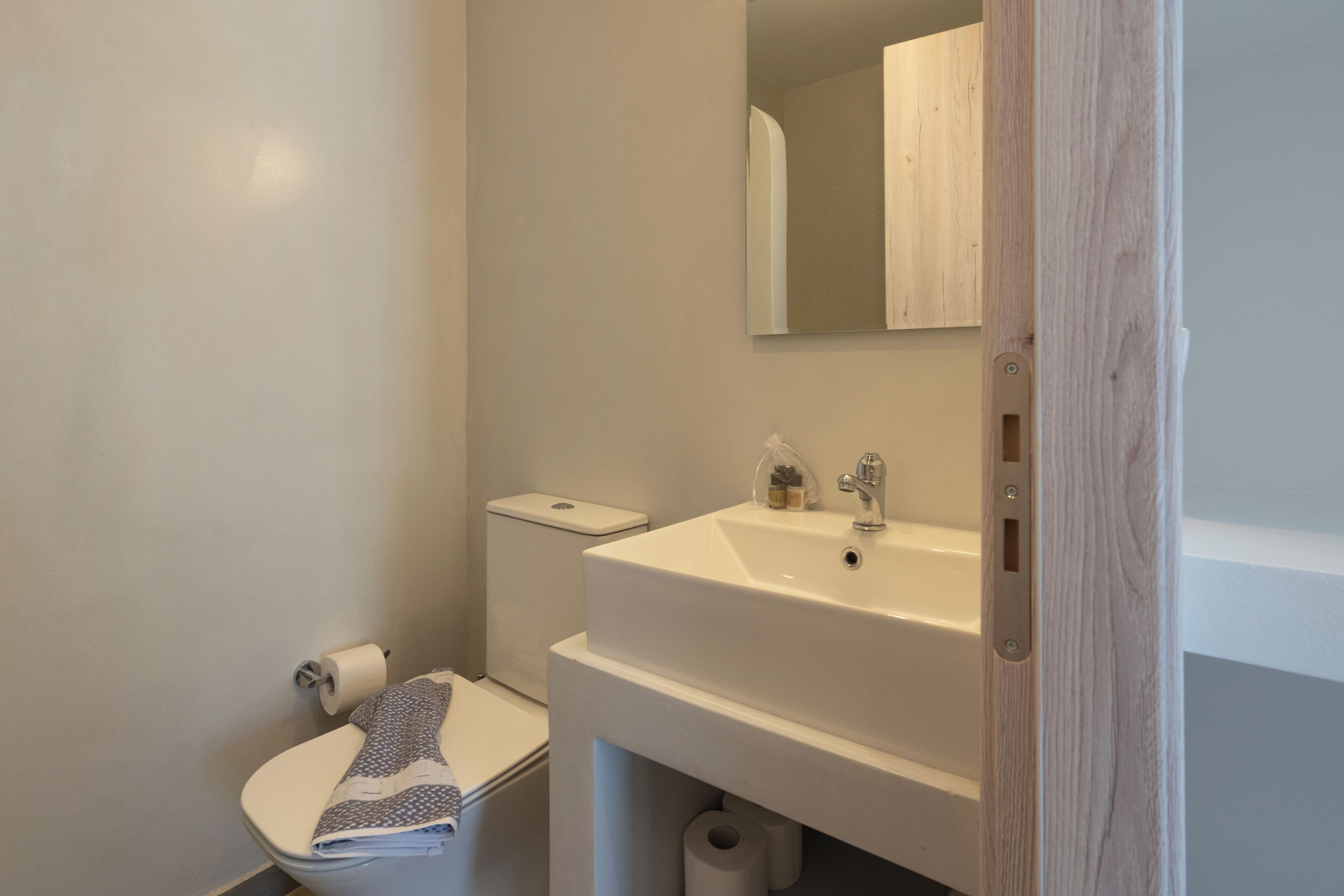 Un baño con inodoro, lavabo y espejo.