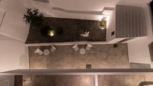 A modern interior with a central seating area, a vertical garden, and a staircase. - Bedspot Apartments Astypalaia (Astypalaia)