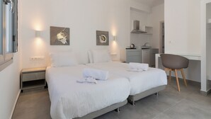 A modern hotel room with a double bed, bedside tables, a desk, and a chair. - Bedspot Apartments Astypalaia (Astypalaia)