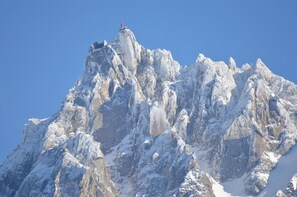 A snow-covered mountain peak with a small structure on top.