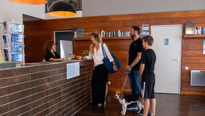 A reception area with a reception desk, a wooden wall, a tiled floor, and a dog on a leash. - Studio for 4 with terrace, pool and parking in Jausiers (Jausiers)
