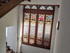 Una ventana de vitral con diseños intrincados y un marco de madera.