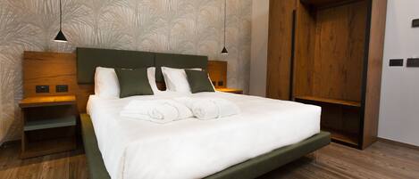 Quarto moderno com uma cama grande, cabeceira de madeira e guarda-roupa embutido.