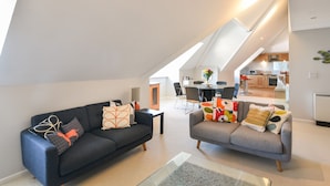 Eine moderne Loft-Wohnung mit Essbereich, Küche und zwei Sofas.
