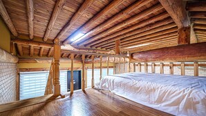 A room with a wooden ceiling, a bed, a window with blinds, and a brick wall. - Gapyeong Acimpunggeongpension (Gapyeong)