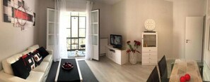 Una sala de estar moderna con un sofá, una mesa de centro, un televisor y adornos.