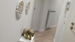 A hallway with a radiator, a door, and decorative wall art.