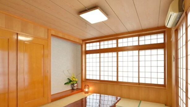 A traditional Japanese room with tatami flooring, a low wooden table, sliding doors, and a large window with shoji screens. - Wing Mihama Beach (Chatan)