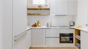 A compact kitchen with white cabinets, a built-in oven, and a sink. - Casa Lazzaro Contemporary Ground Floor Apartment (Lucca)