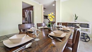 A dining area with a wooden table set for four, including plates, cutlery, and glasses.