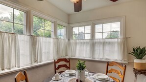 A dining room with a table set for four, surrounded by chairs, with a window view and a ceiling fan. - 6 Mi to Shoshone Falls! Charming Idaho Home (Twin Falls)