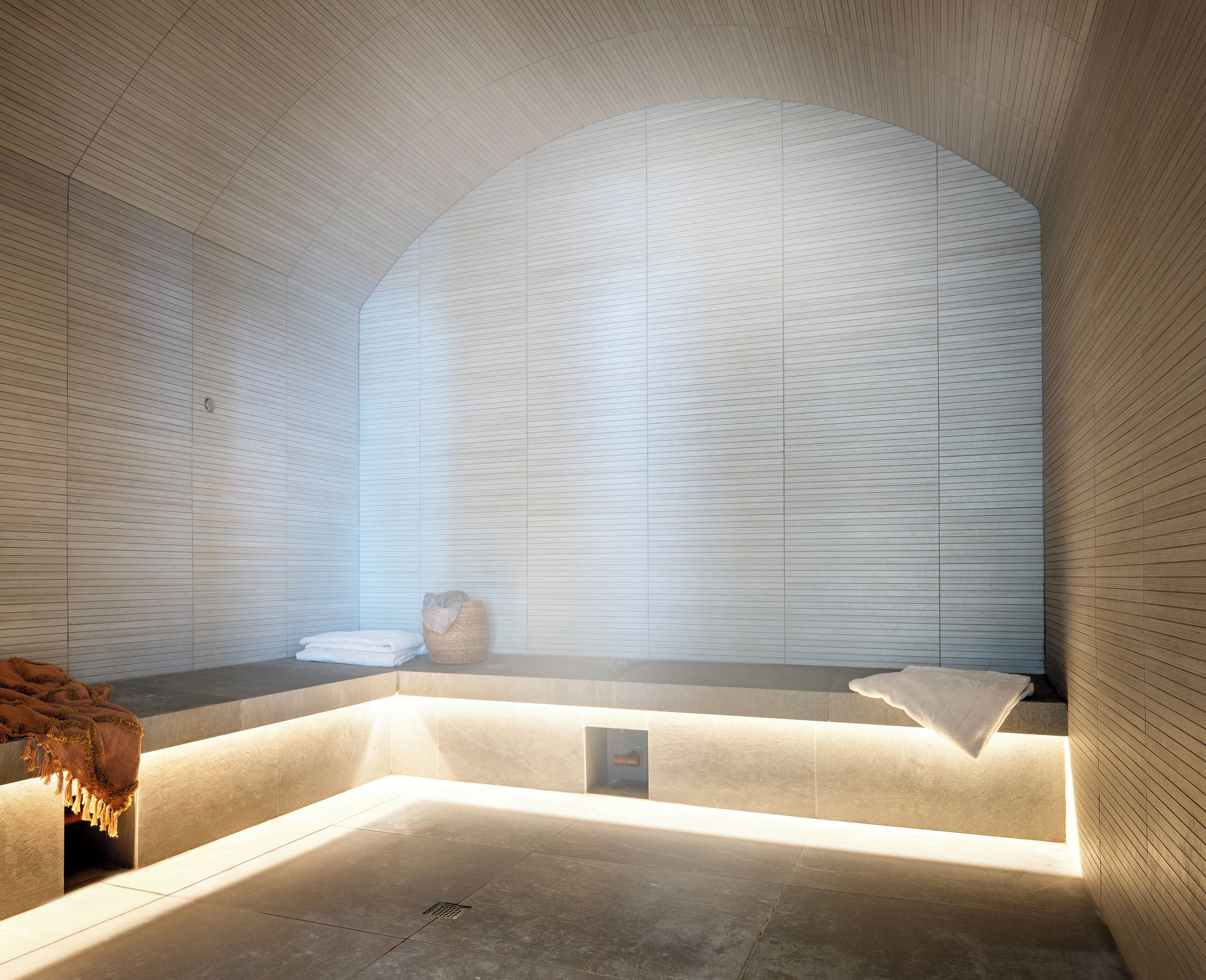 Une salle de bain moderne avec une grande baignoire, un petit lavabo et un porte-serviettes.