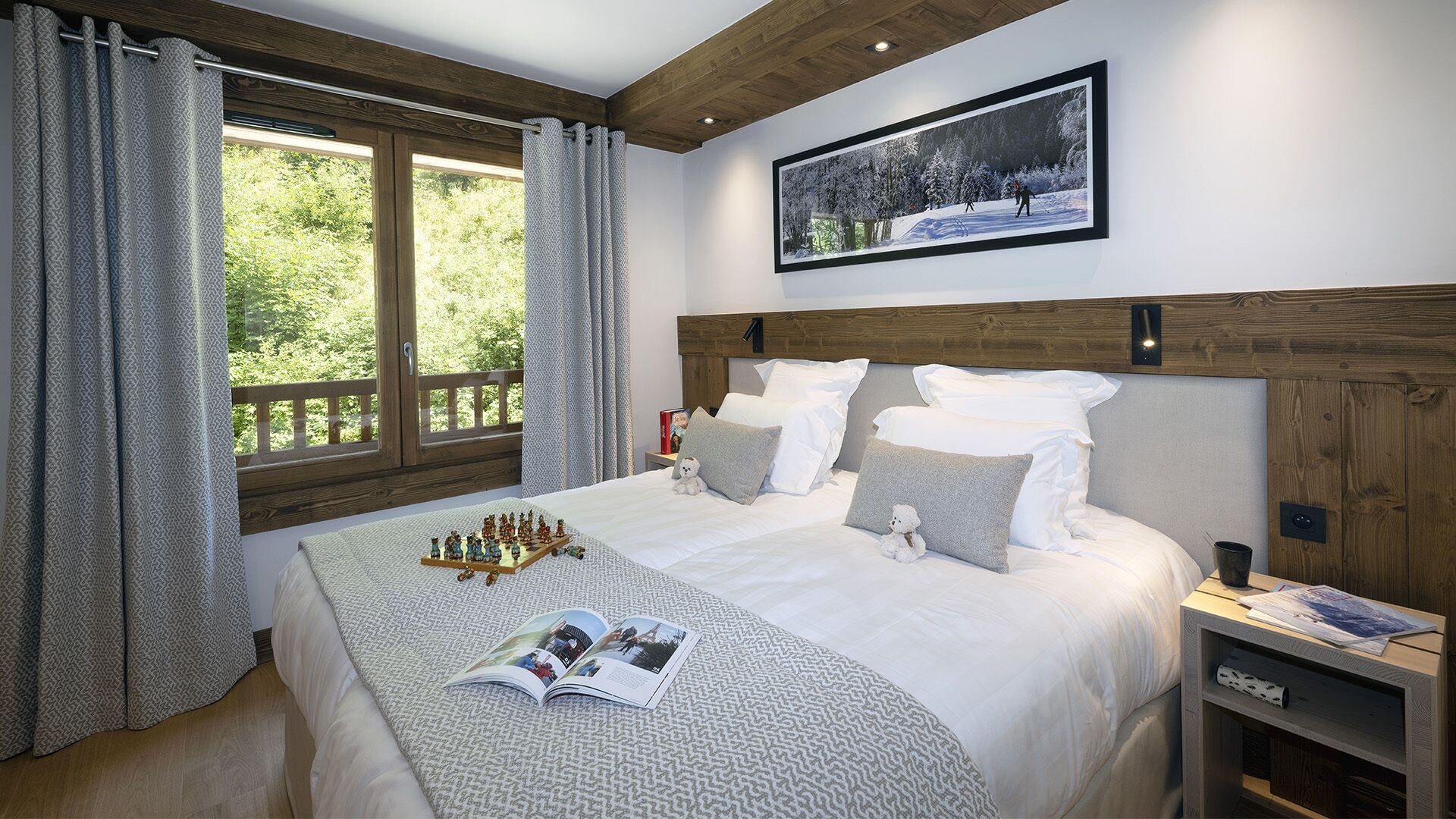 A bedroom with a large bed, wooden headboard, and a window with curtains.
