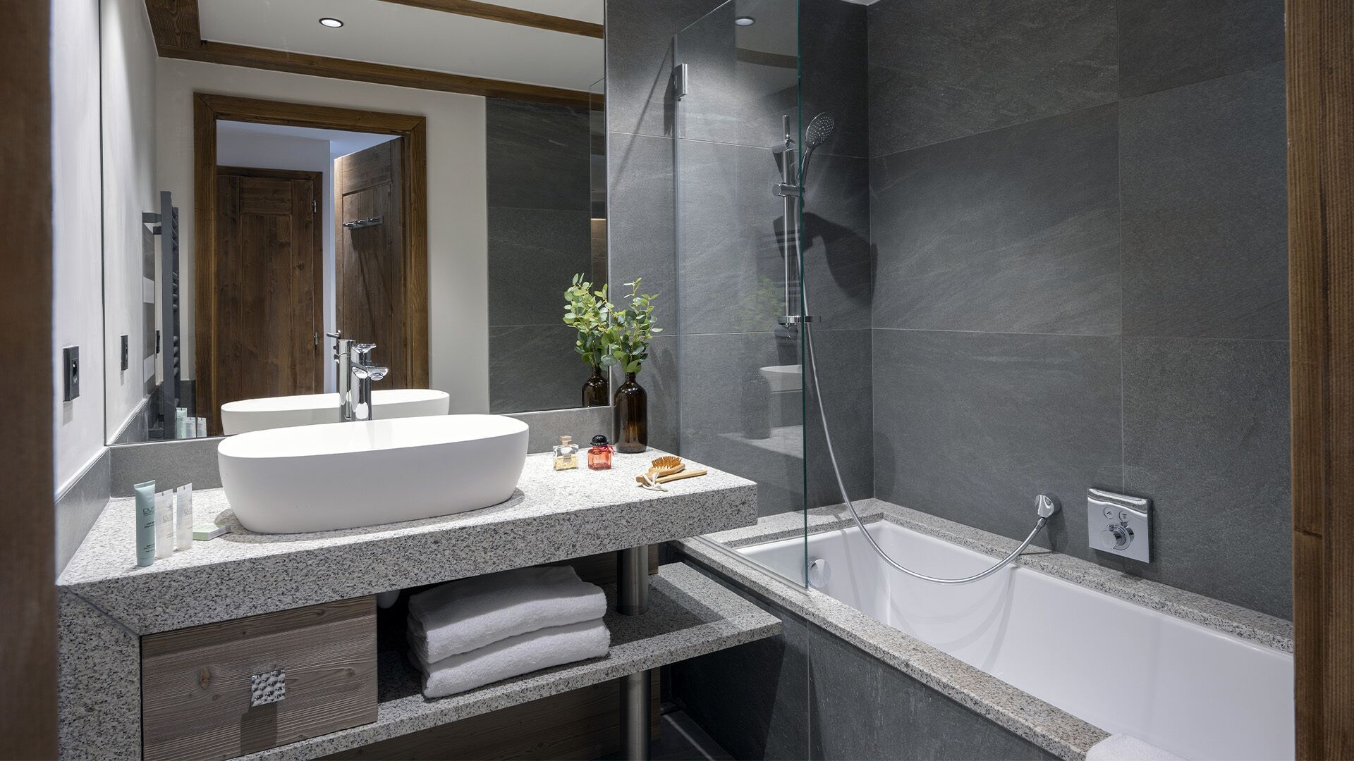 A modern bathroom with a large freestanding bathtub, a double sink vanity, and a glass-enclosed shower area.
