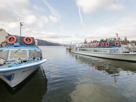 Dos barcos amarrados en un muelle, con boyas salvavidas a los lados.