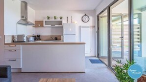 Una cocina moderna con una isla central, electrodomésticos integrados y un amplio ventanal que proporciona luz natural.