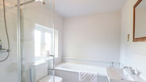 A bathroom with a glass-enclosed shower, a white toilet, a bathtub, and a sink.