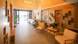 A modern interior with a reception desk, seating area, and decorative elements. - Krem Marin Suites (Cesme)