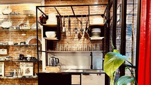 Une cuisine moderne avec un mur en briques, des armoires en bois et une grande fenêtre.
