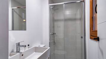 Een douche, een haardroger, pantoffels, handdoeken