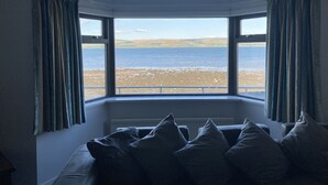 A room with a bay window overlooking a beach. - Waters Edge (Stranraer)